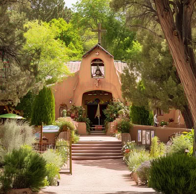 a church with a steeple surrounded by trees