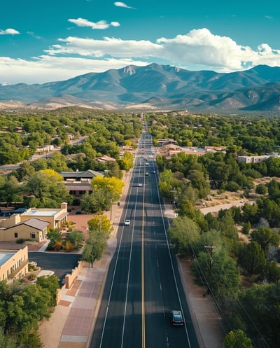 a road in Santa Fe with a car driving down it