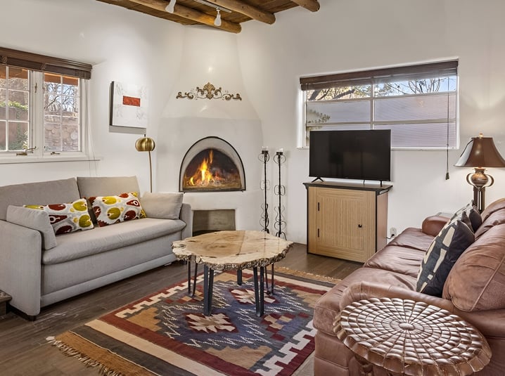 a living room with a couch, TV, and a fireplace