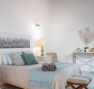 A bedroom with a bed and a small table