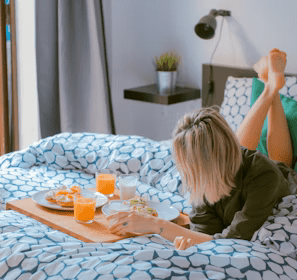 woman lying on bed white holding board