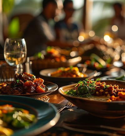 A table with plates of food and wine glasses