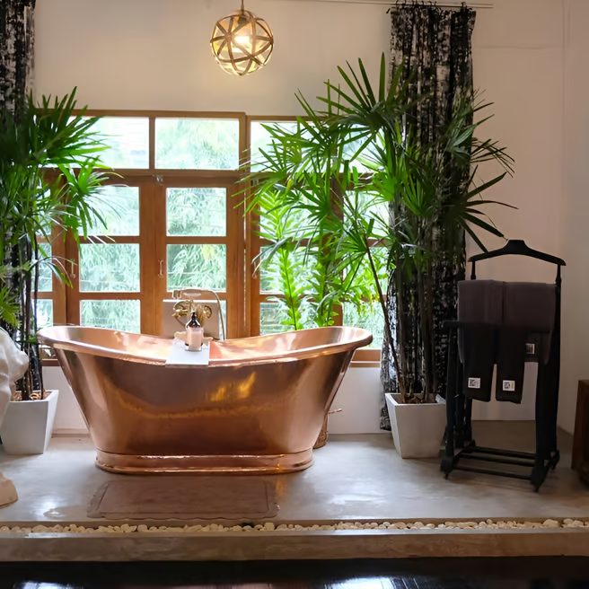 A large copper bathtub and a statue of a head A large copper bathtub and a statue of a head