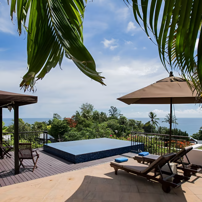 A deck with lounge chairs and umbrellas A deck with lounge chairs and umbrellas