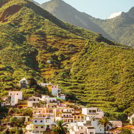 A picturesque mountain village with lush green hillside, nestled in the serene beauty of nature.