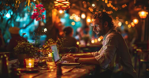 a man sitting at a table with a laptop computer