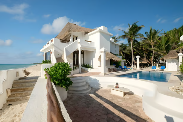 A white house with a pool and a view of the ocean in playa del carmen A white house with a pool and a view of the ocean in playa del carmen