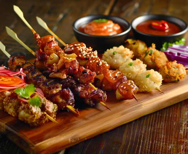 Assortment of colorful Balinese Sate varieties on a rustic wooden board. Assortment of colorful Balinese Sate varieties on a rustic wooden board.