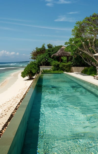 Elegant beachfront villa in Dyanapura with a sleek pool surrounded by tropical flora and ocean views.