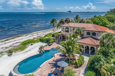 Aerial shot of a beachfront property, emphasizing its elegant design and breathtaking views of the ocean in Bradenton.