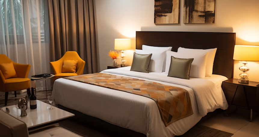 A bed sitting in a bedroom next to two yellow chairs
