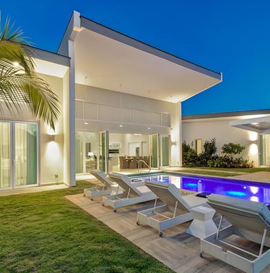 a pool with lounge chairs and a palm tree in Barbados a pool with lounge chairs and a palm tree in Barbados