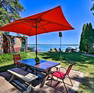 a table with a red umbrella and chairs of a house by the lake in Madison, Wisconsin