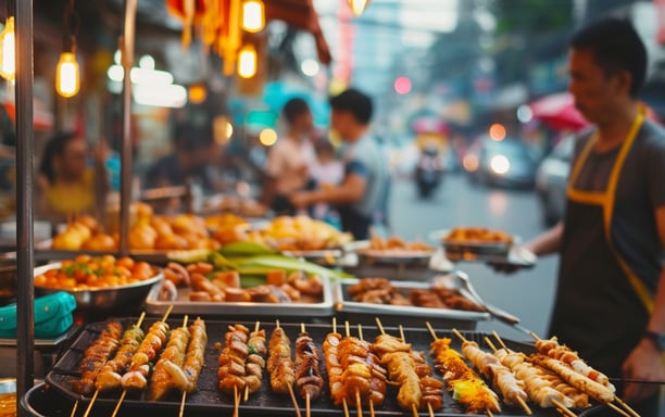 A Western tourist trying out street food in a busy Bangkok street. A Western tourist trying out street food in a busy Bangkok street.