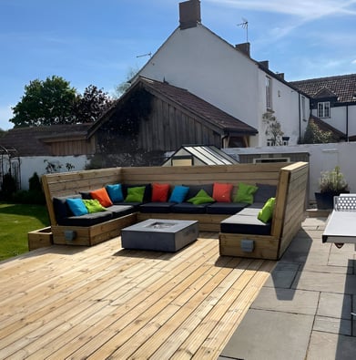 A couch with colorful pillows on a deck of a manor in Coalpit Heath, UK