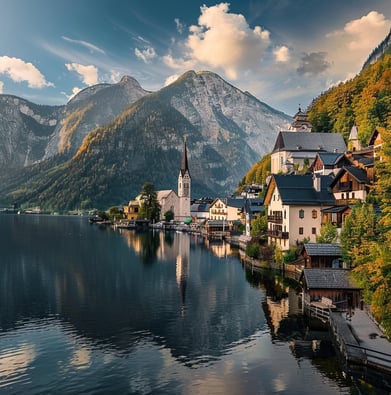 A lake with a church and mountains in the background in Hallstatt, Austria