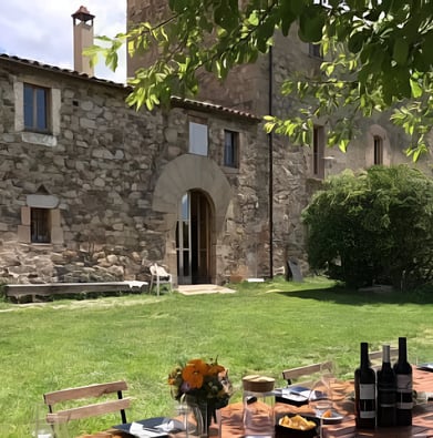A cottage house with a table setting outside in catalonia