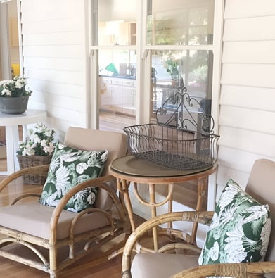 A patio with wicker chairs and a table at a cottage in Harcourt North, Victoria