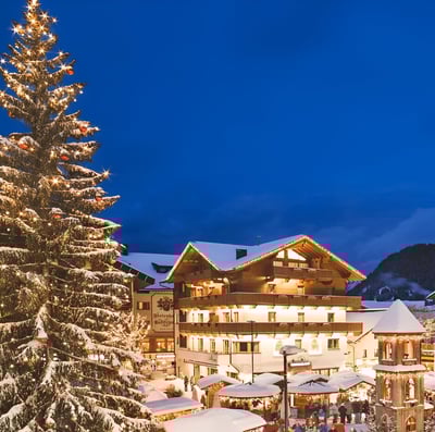 A christmas tree beside a snow-covered apartment in innsbruck, austria