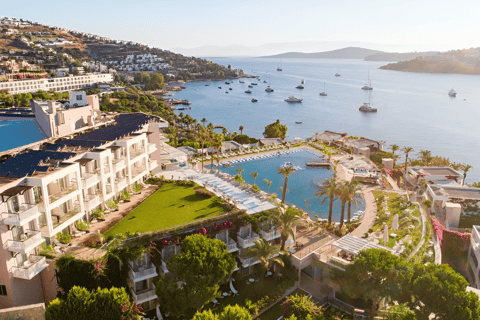 a hotel in front of a large body of water with a lot of boats in it a hotel in front of a large body of water with a lot of boats in it