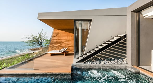 a beachfront cottage with a thatched roof and palm trees a beachfront cottage with a thatched roof and palm trees