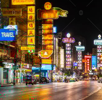 City skyline at night with colorful neon signs illuminating the streets