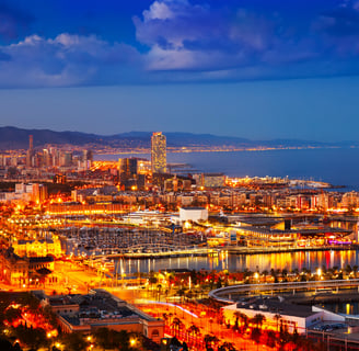 Barcelona cityscape at night with illuminated lights reflecting on the water