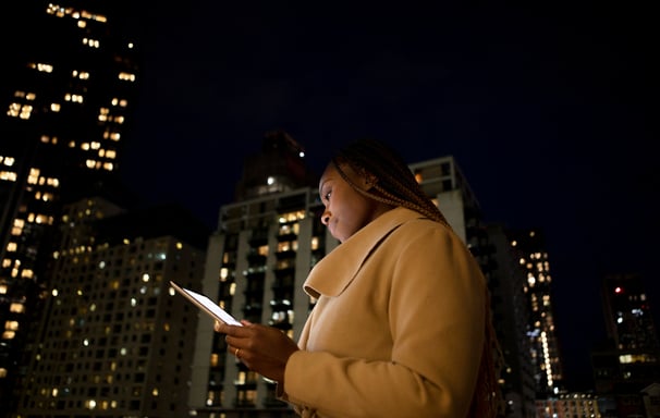 a woman in a coat and hat holding a cell phone