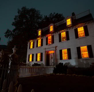 Illuminated house at night, glowing warmly with lights shining through windows