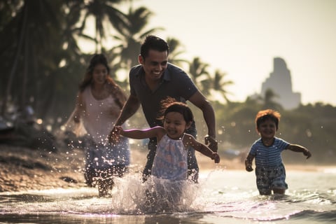 A family joyfully running through the water at the beach on a sunny day.