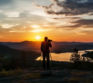 A man with a camera capturing the sunset's beauty.