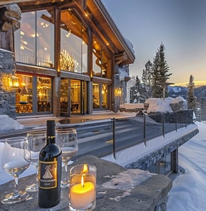 Winter luxury at a mountain lodge with wine and candles at dusk.