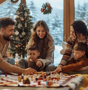 Family enjoys a board game by the Christmas tree in a cozy cabin.