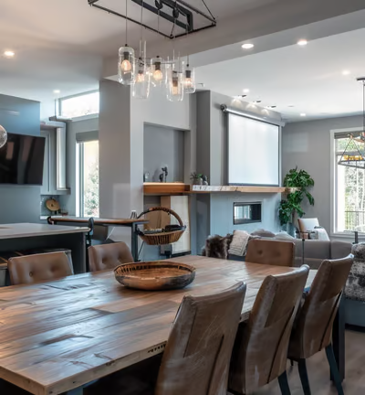 A minimalist studio apartment with space divided by dark curtains, featuring a compact kitchen, a small dining area, and bath