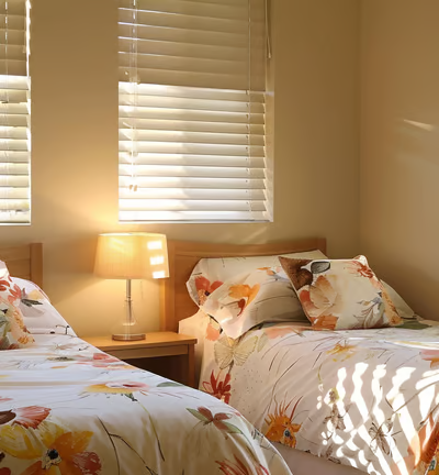 two beds in a room with two lamps on each side