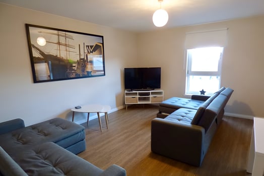 a living room with a couch and a television in east end glasgow