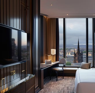 A bedroom with a large bed and a television in glasgow