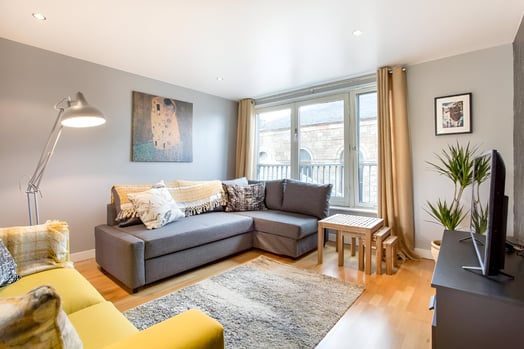 a living room with a couch and a television in a hotel in east end glasgow