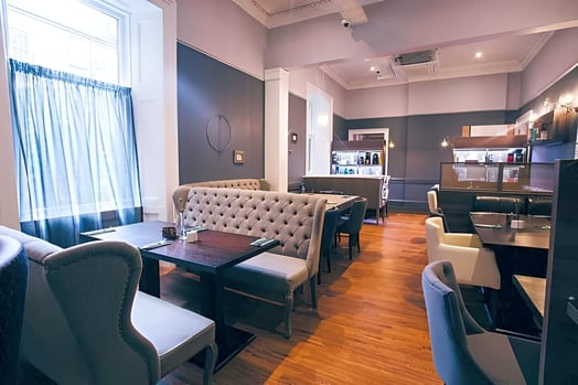 a hotel room with a couch, chairs, and a table in merchant city glasgow
