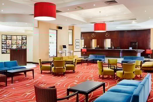 a hotel lobby with a red carpet and chairs in merchant city glasgow