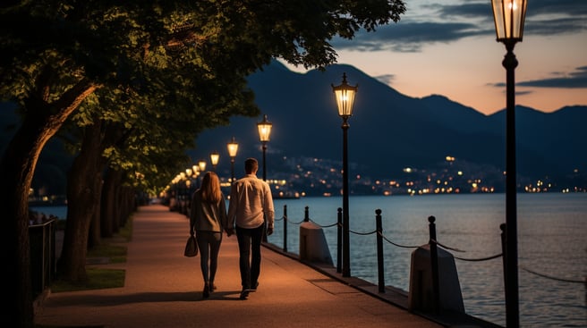 A couple walking along Menaggio's lakeside promenade at night