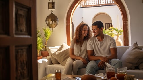 A man and woman sitting on a couch in a living room A man and woman sitting on a couch in a living room