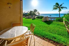 a patio table and chairs in front of a large lawn a patio table and chairs in front of a large lawn