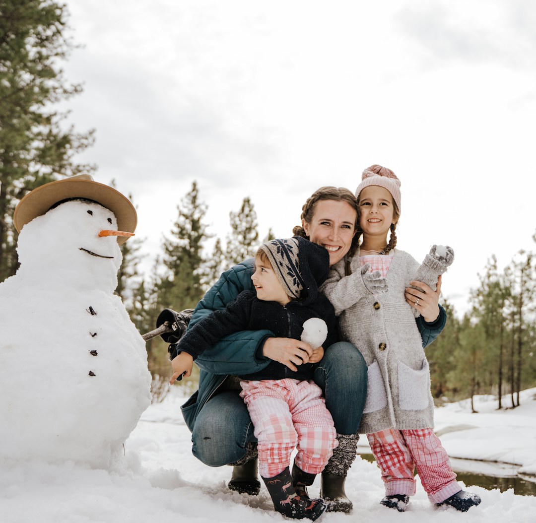 2 girls sitting on white snowman