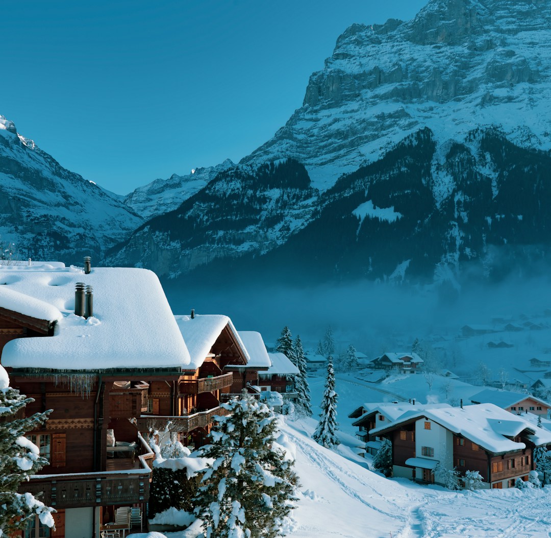 a snow covered mountain with a house in the foreground