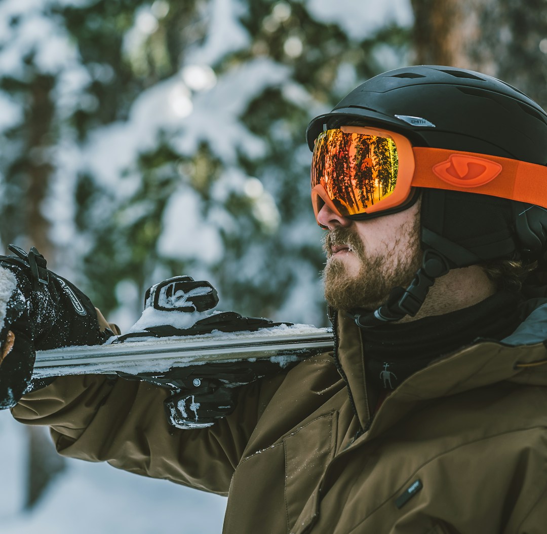 man in brown jacket wearing orange and black helmet