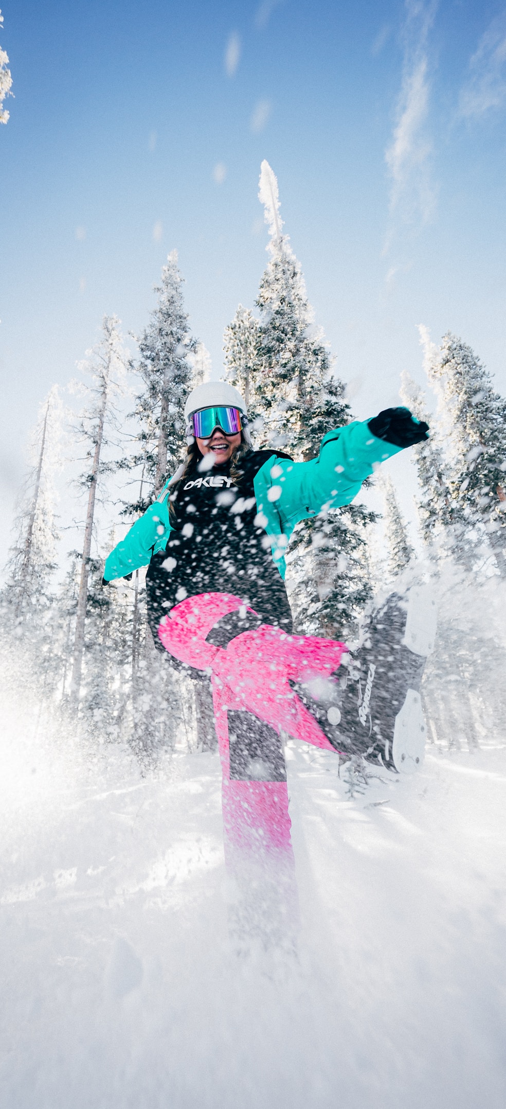 person in blue jacket and pink pants riding on snowboard during daytime