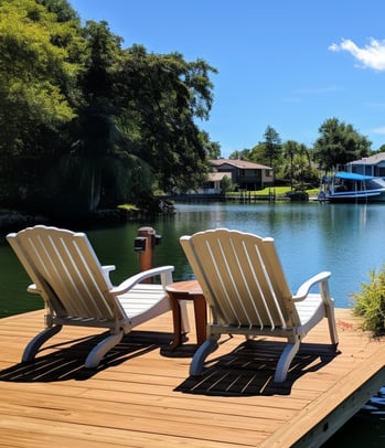 two chairs on a dock with a boat in the water