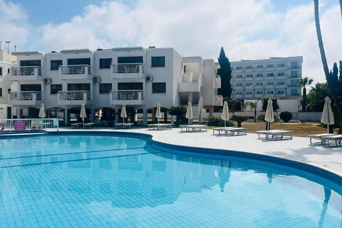 a large swimming pool and lounge chairs a large swimming pool and lounge chairs