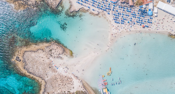 seashore and beach houses with people next to a calm sea